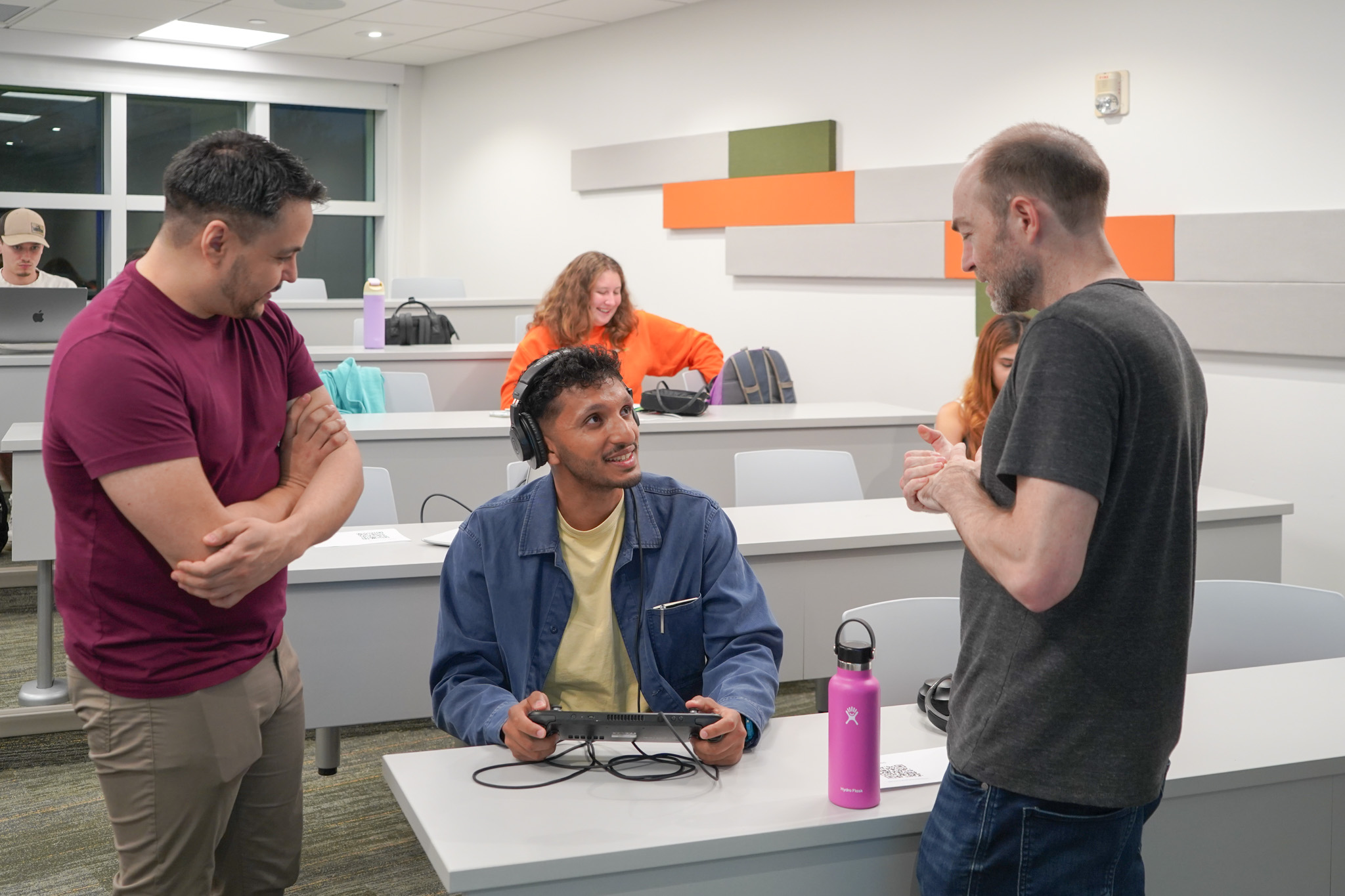 Small group observing gameplay at the NERDLab Arcade