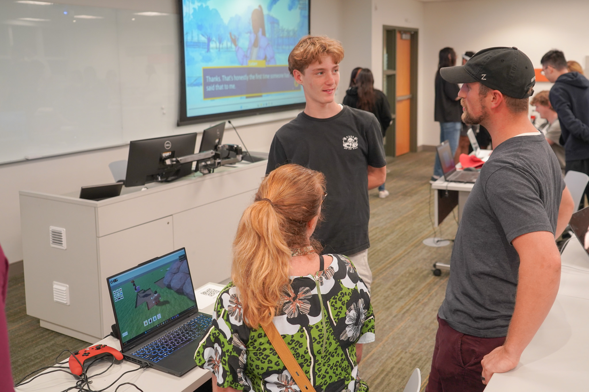 Students talking while a game runs in the background